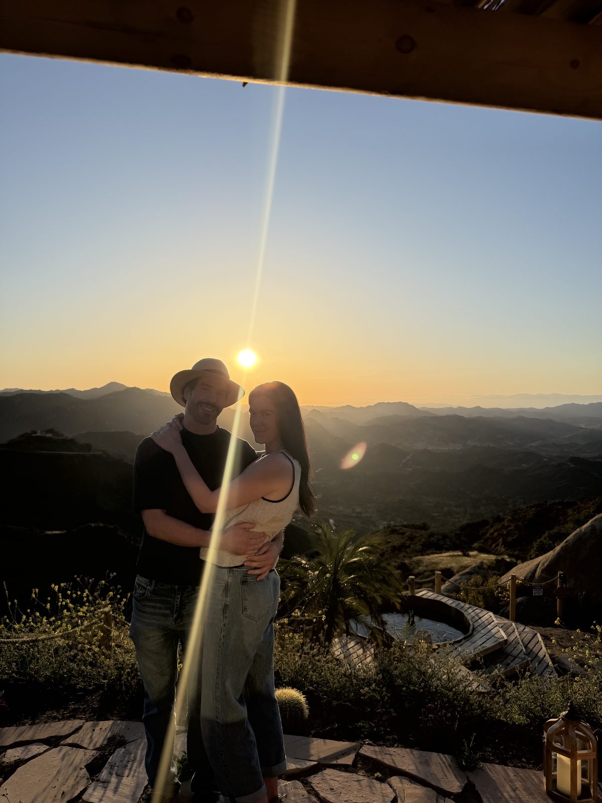 Embracing at sunset over the mountains